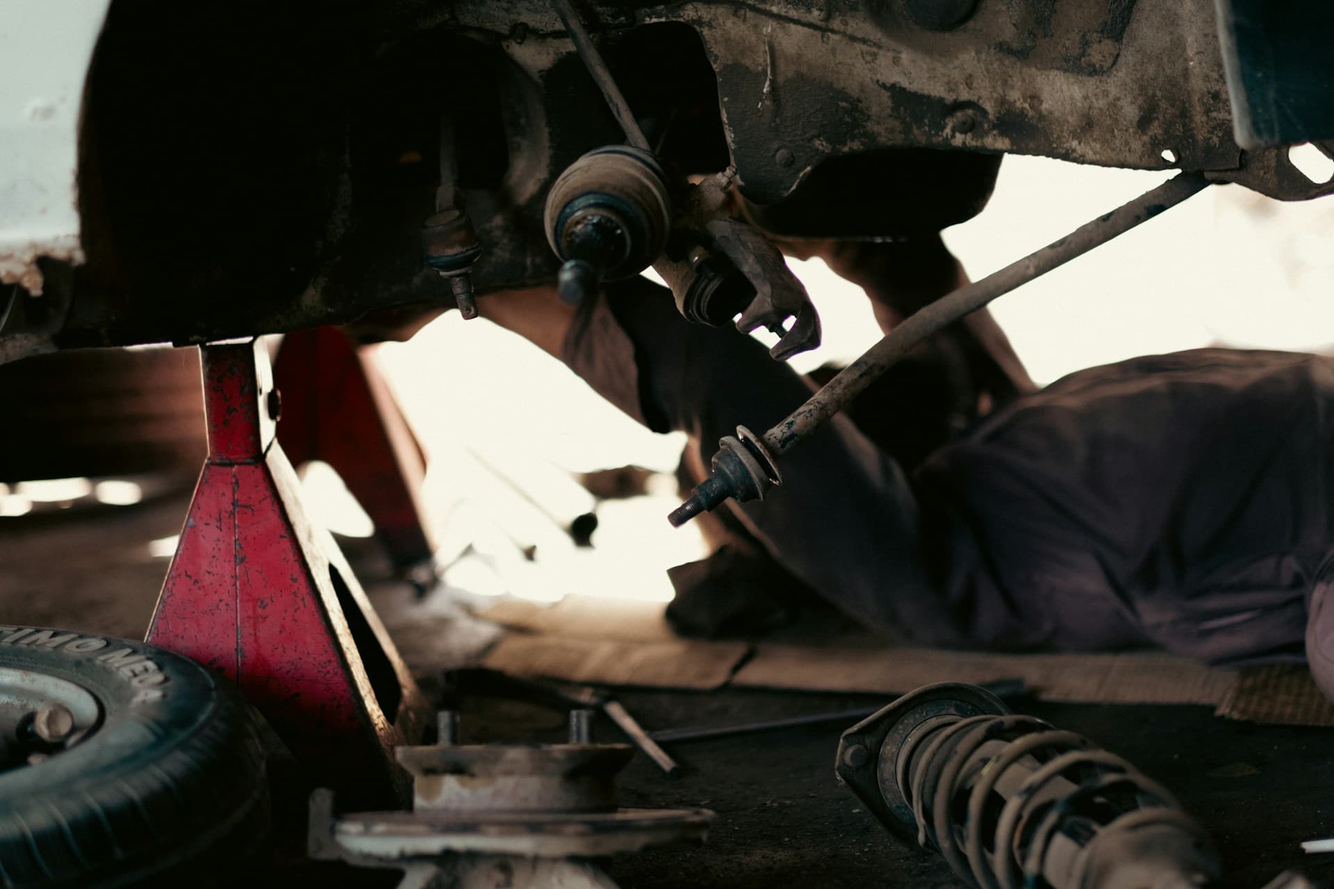 A mechanic working under a car, the kind of inspection an MOT test records